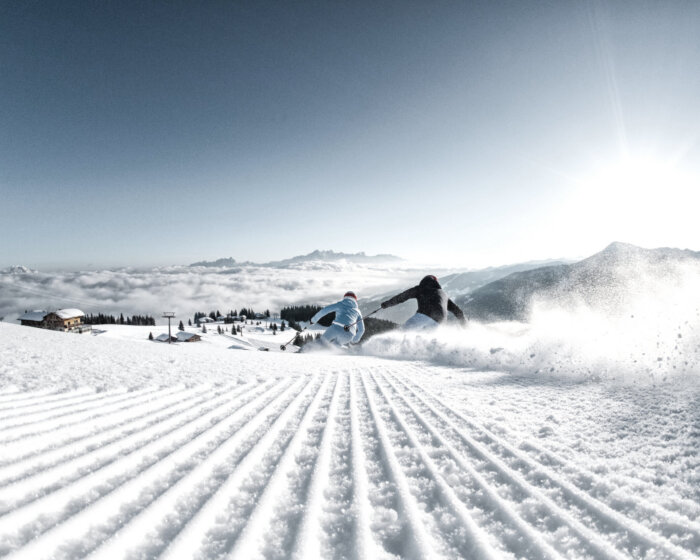 Piste Skifahren Pärchen, frisch präparierte Piste