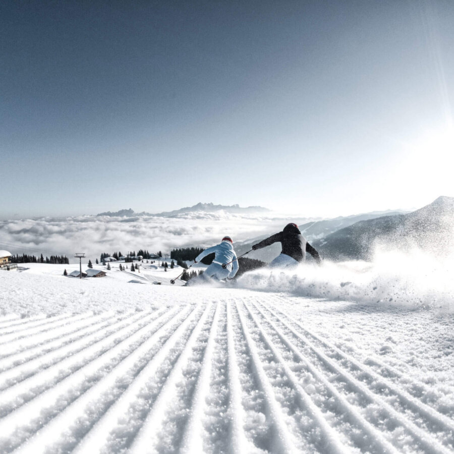 Piste Skifahren Pärchen, frisch präparierte Piste